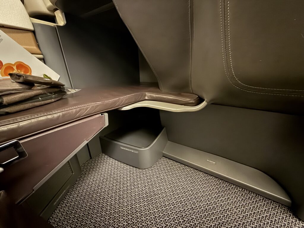 Close up of storage space for personal items in Singapore Airlines Business Class seat.