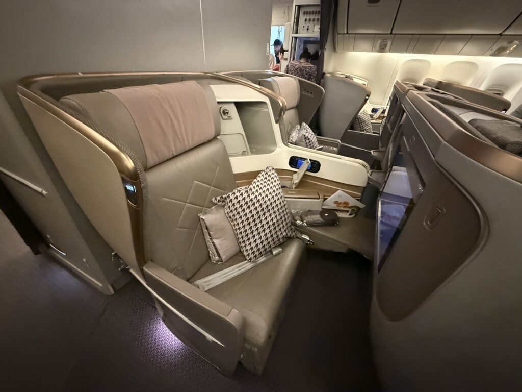 luxurious business class seat with wide seat, plush pillow and large center console.