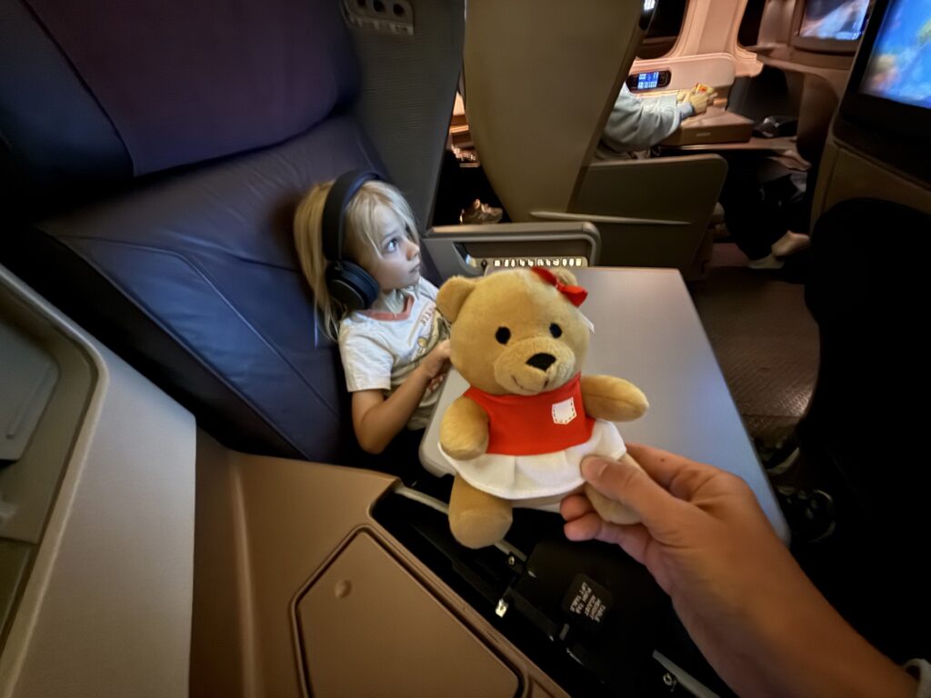Small stuffed bear in a red and white outfit.